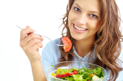 Close-up of pretty girl eating fresh vegetable salad